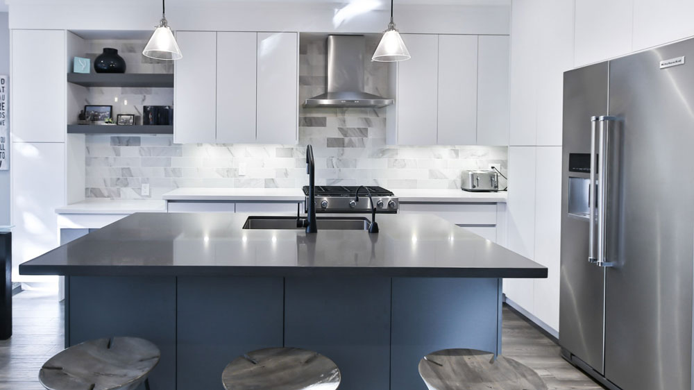 A sleek, futuristic kitchen with all stainless steel appliances and blue cabinets
