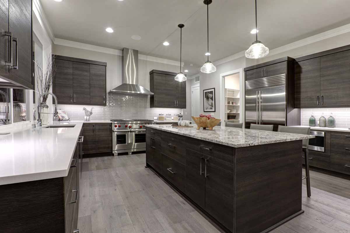 A kitchen with granite countertops and dark wooden cabinets