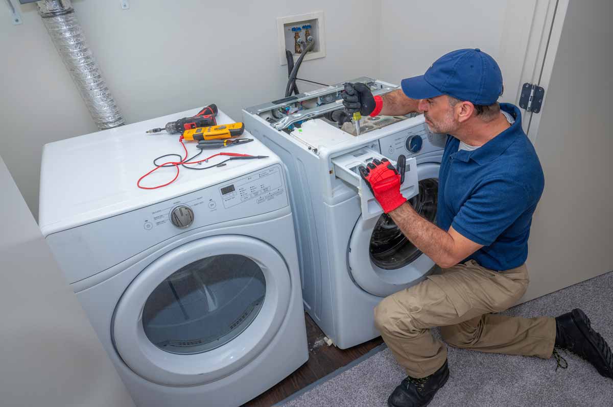 A repair man working on a washing machine