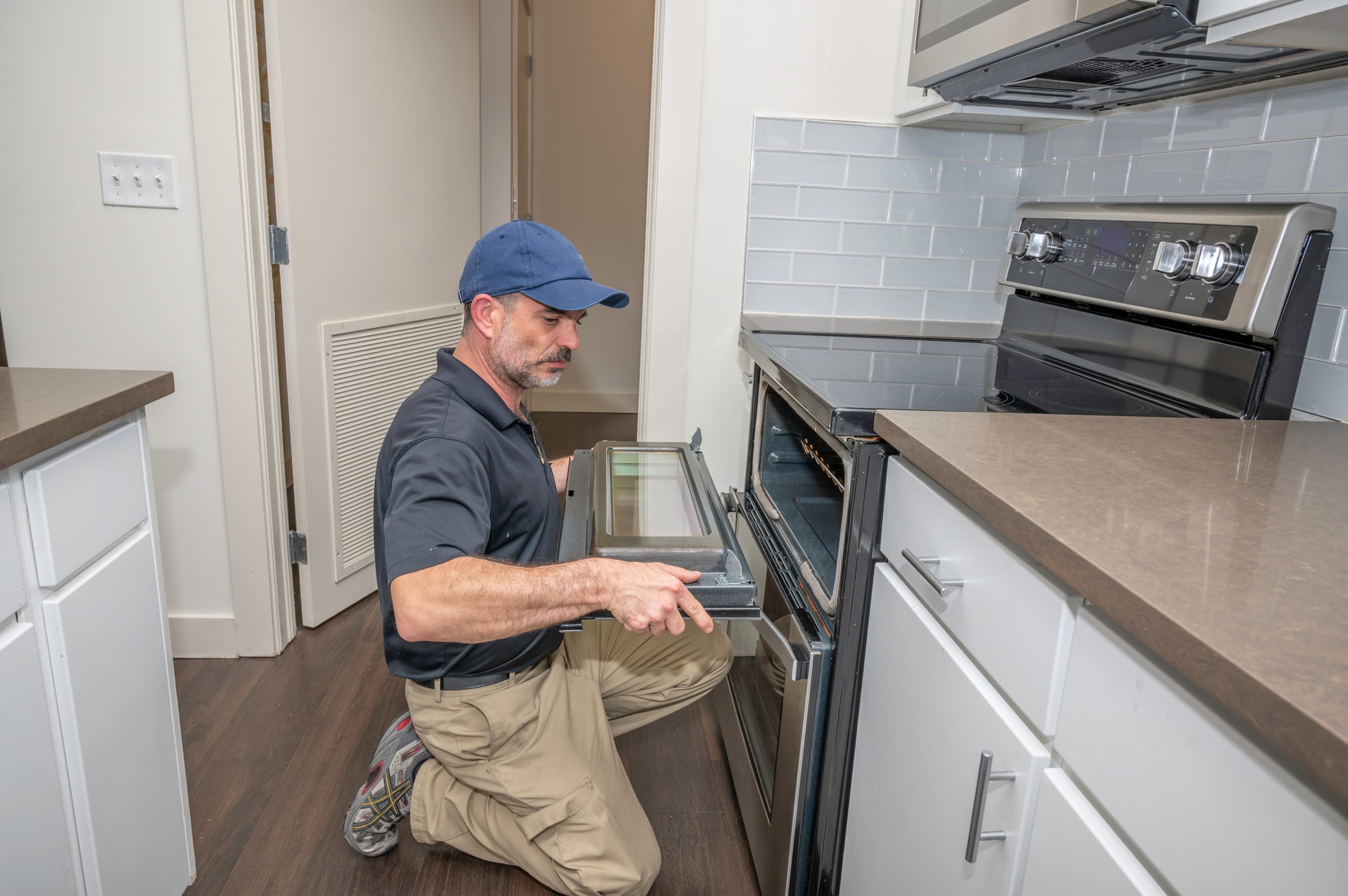 Appliance technician installing a oven door on a modern range