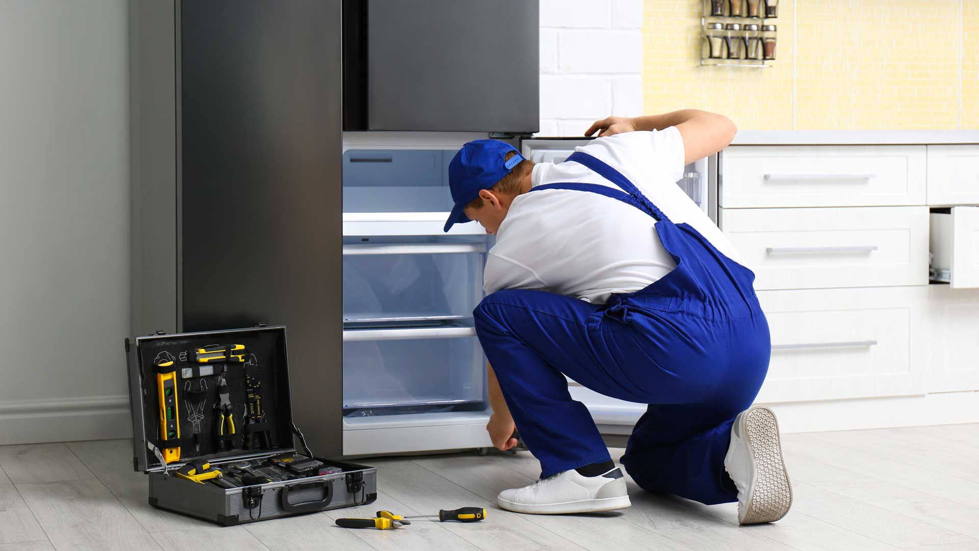 A technician repairing a refrigerator