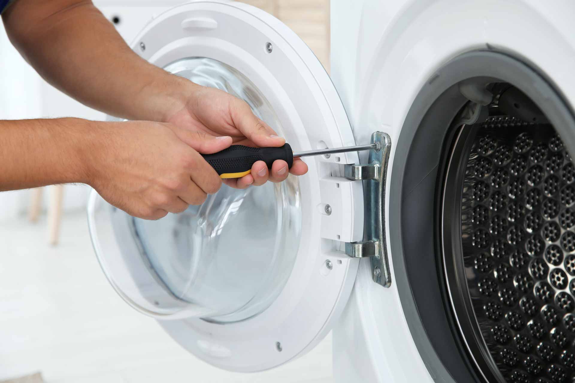 Close-up shot of a technician fastening the door on a clothes dryer